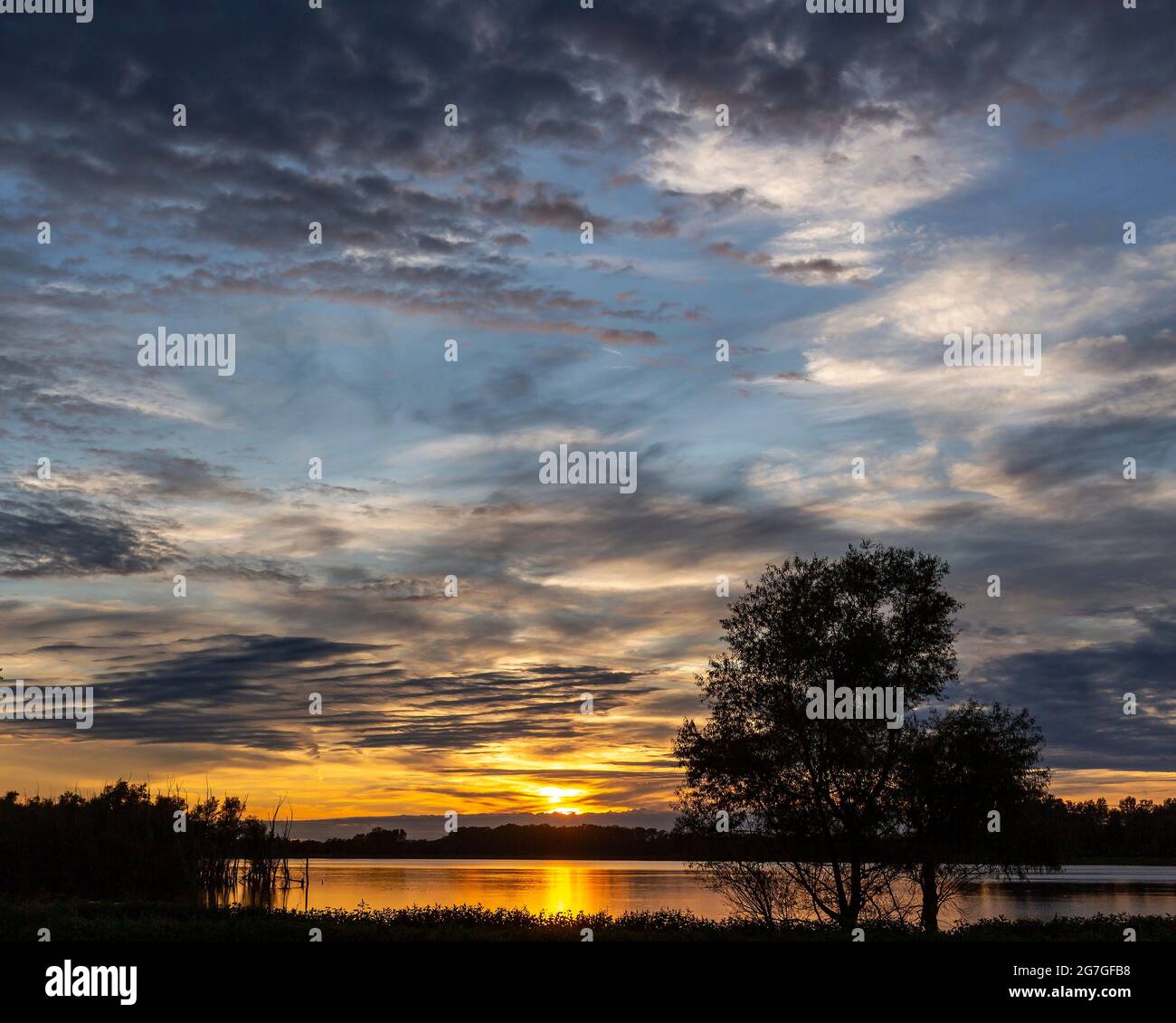 Tramonto scenico riflesso nelle acque di un lago rurale di campagna Foto Stock