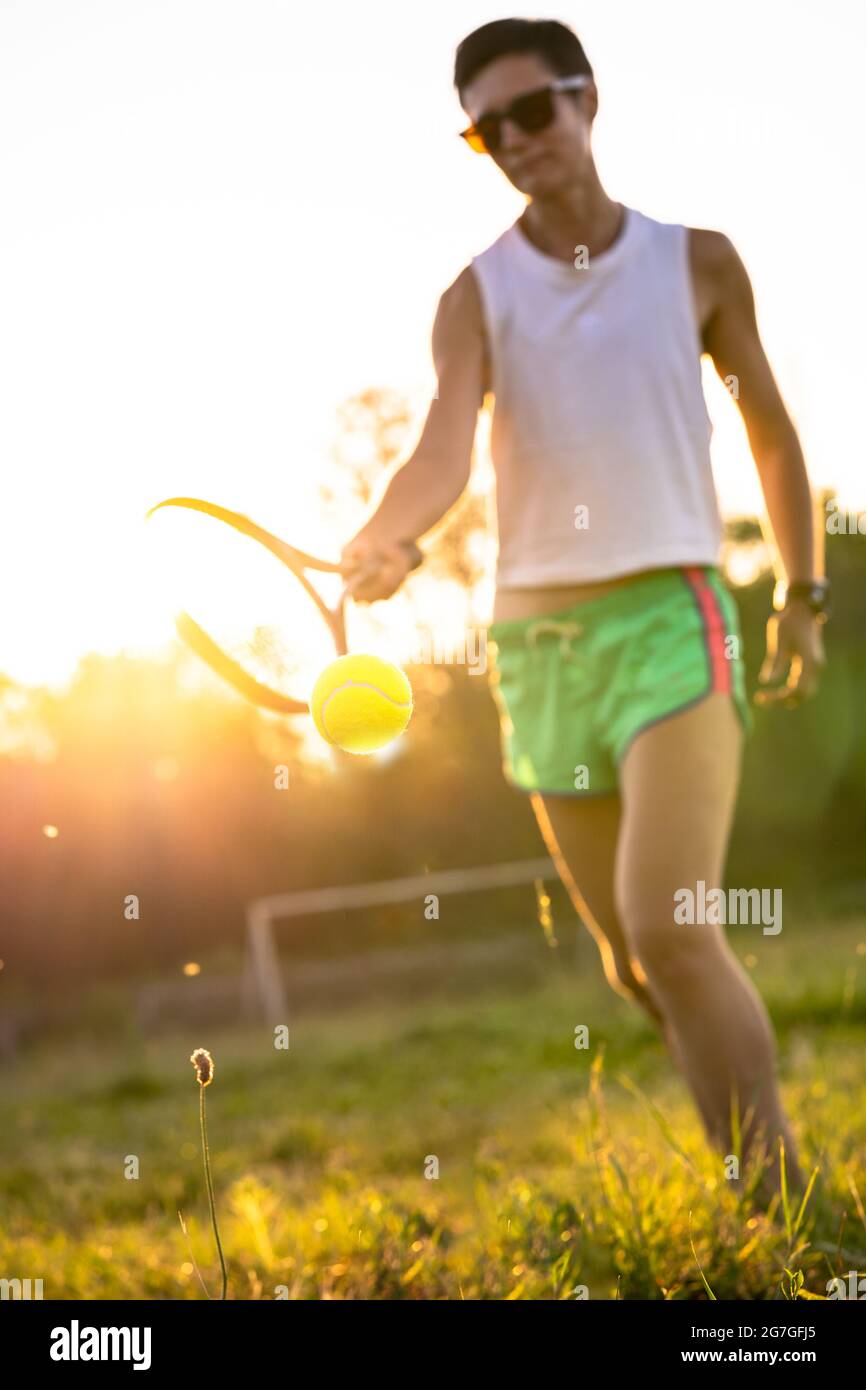 Giovane bella donna con capelli corti giocare a tennis all'aperto Foto Stock