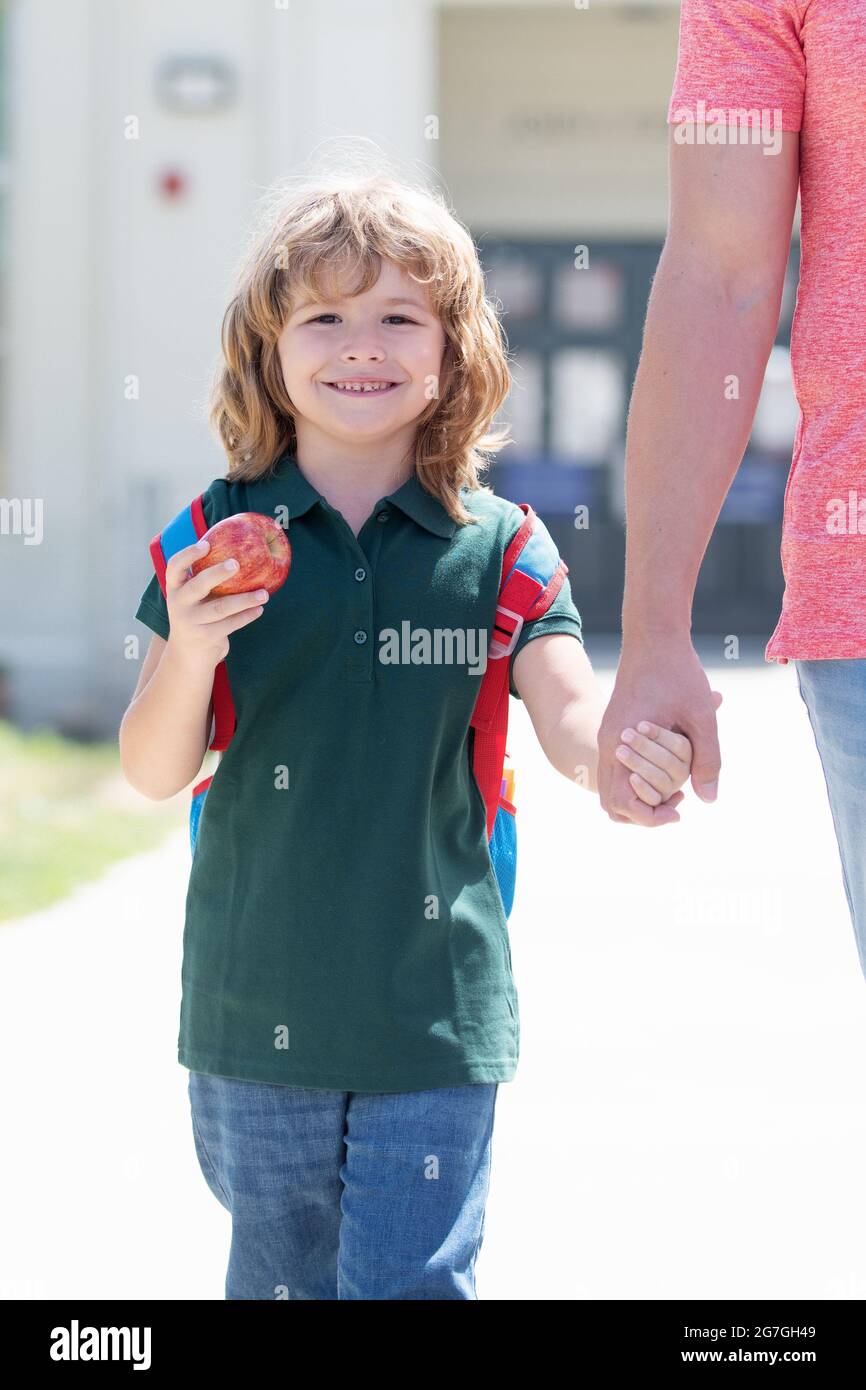 il figlio torna dalla scuola tiene i padri mano. buon valore della famiglia. infanzia. Foto Stock