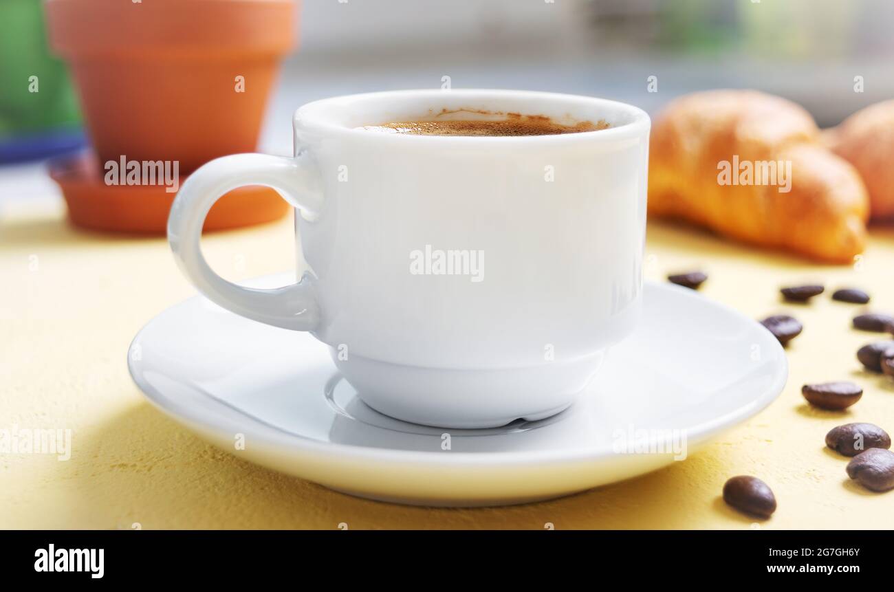 Tazza di caffè, croissant freschi sul tavolo. Colazione tradizionale. Buongiorno. Foto Stock