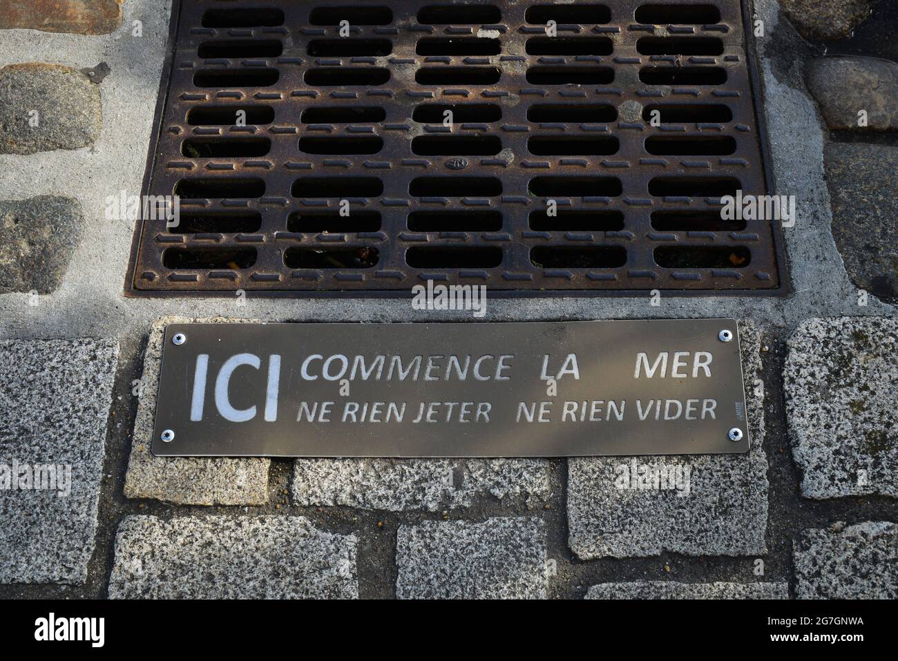 Griglia di evacuazione delle acque con indicazione 'il mare inizia qui',  testo francese di sensibilizzazione sull'inquinamento marittimo Foto stock  - Alamy