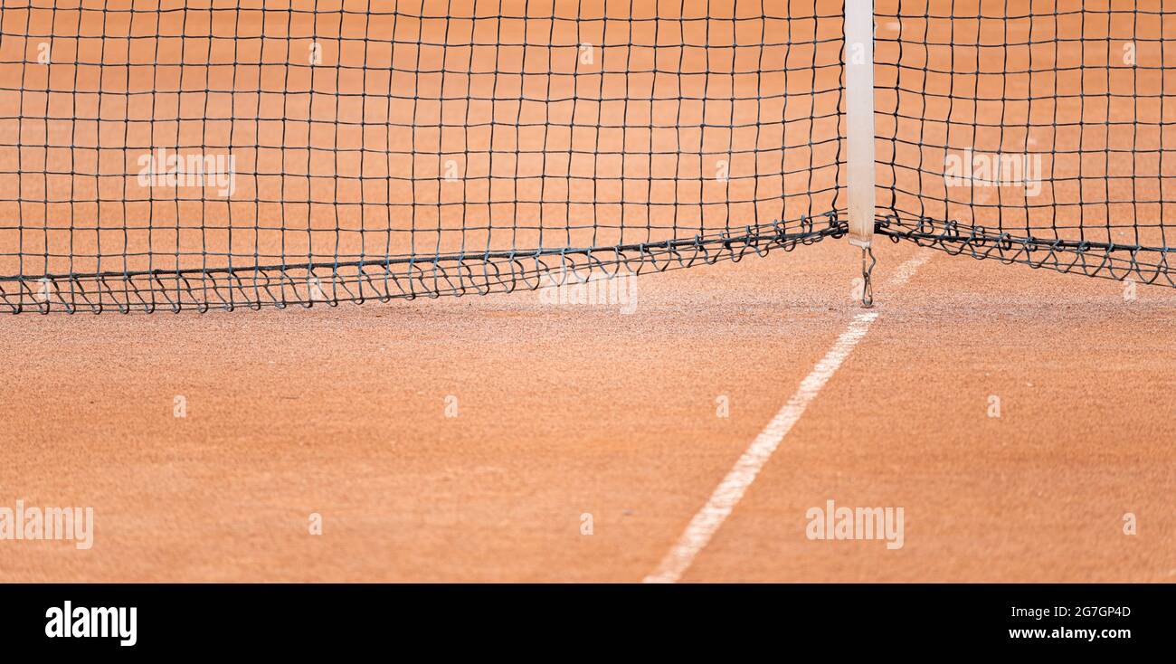 Rosso argilla campo da tennis dettaglio sfondo su linea bianca e rete senza persone Foto Stock