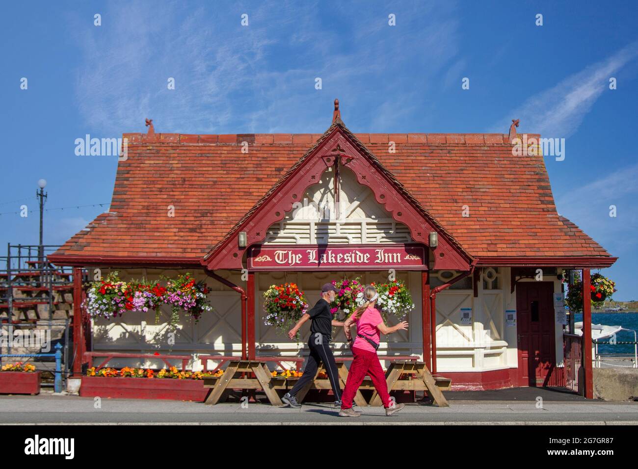 Southport, Merseyside. Regno Unito Meteo 14 Luglio 2021. Cieli estivi e venti leggeri nella località balneare, mentre la gente gode del sole della mattina presto sulla passeggiata lungomare. Lakeside Inn: Il più piccolo pub in Gran Bretagna, (presumibilmente), sul fronte mare. Credito UK; MediaWorldImages/AlamyLiveNews Foto Stock