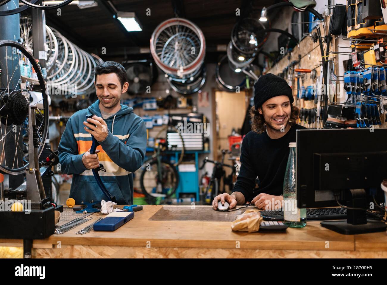Crop cosmetico anonimo applicando maschera di tessuto facciale su cliente femminile durante la procedura di ringiovanimento della pelle nel moderno salone di bellezza Foto Stock