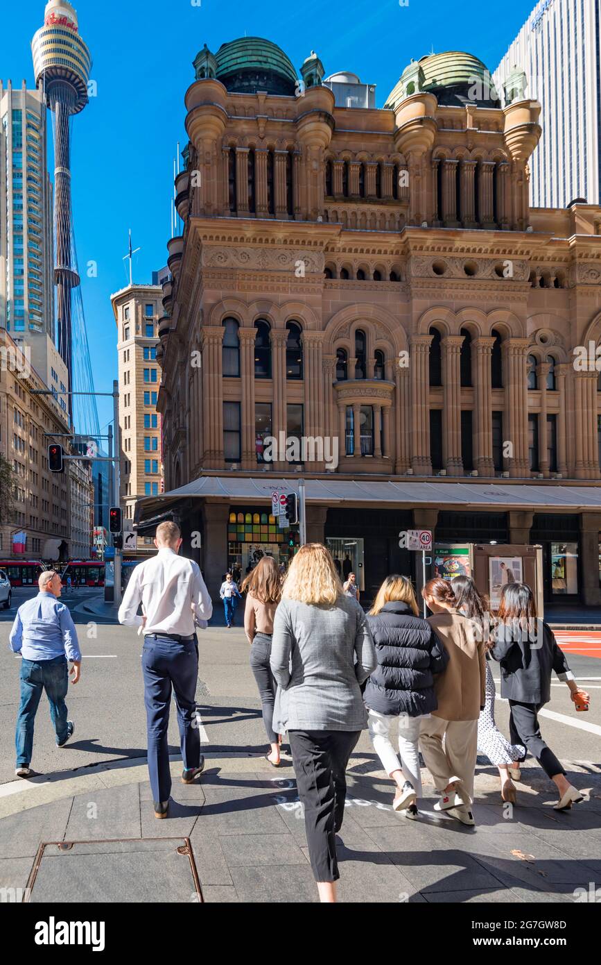 Dirigendosi in direzione del Queen Victoria Building (QVB) e della Sydney Tower, la gente durante il pranzo si interrompe attraversando York Street al semaforo Foto Stock