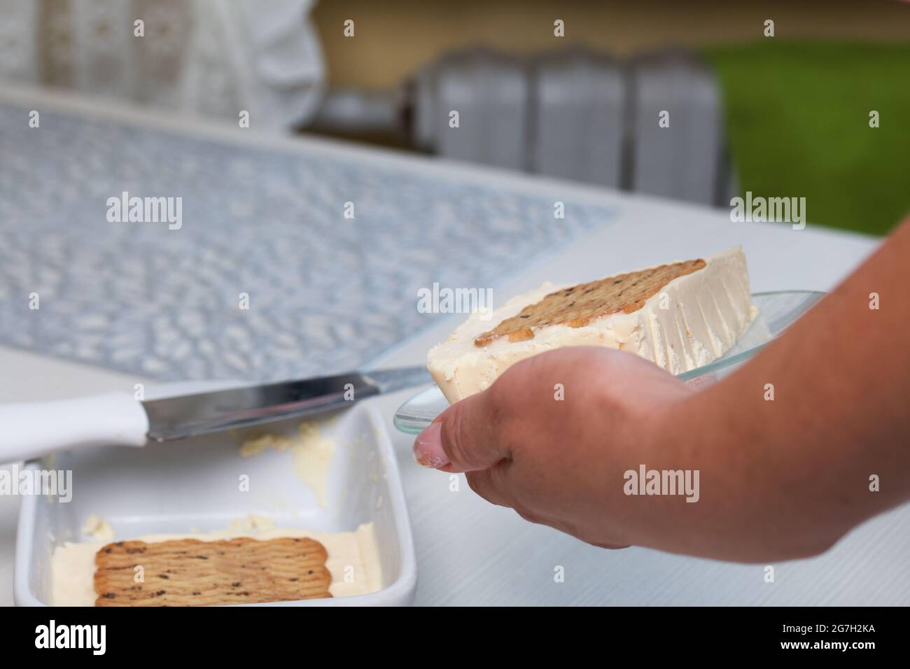 Donna taglia gelato fatto in casa. Biscotti e crema. Primo piano. Foto Stock