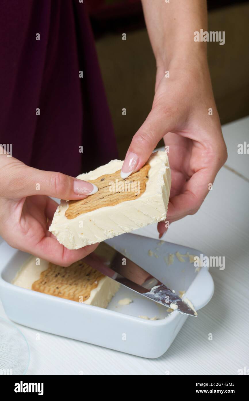 Donna taglia gelato fatto in casa. Biscotti e crema. Primo piano. Foto Stock
