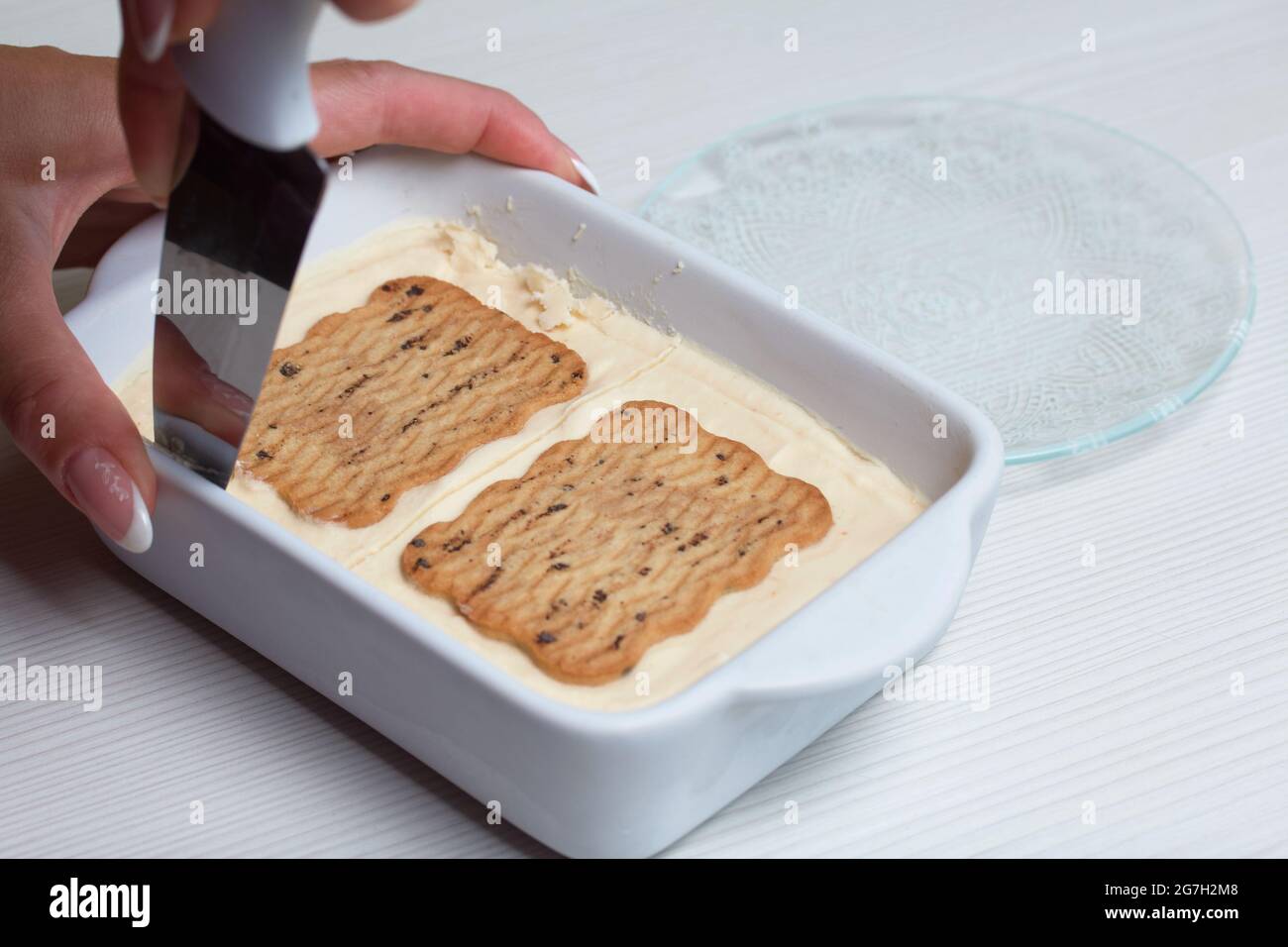 Donna taglia gelato fatto in casa. Biscotti e crema. Primo piano. Foto Stock