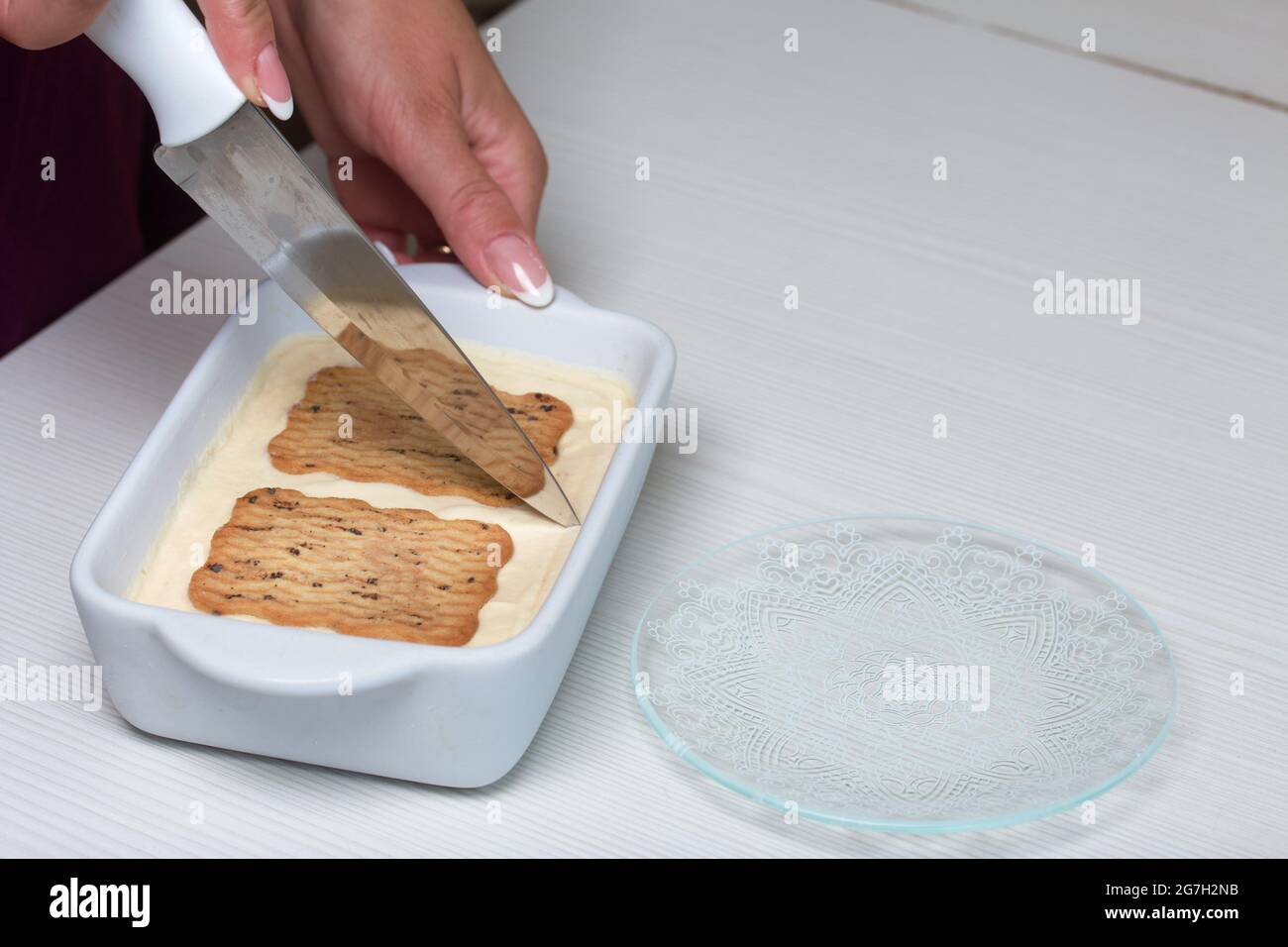 Donna taglia gelato fatto in casa. Biscotti e crema. Primo piano. Foto Stock