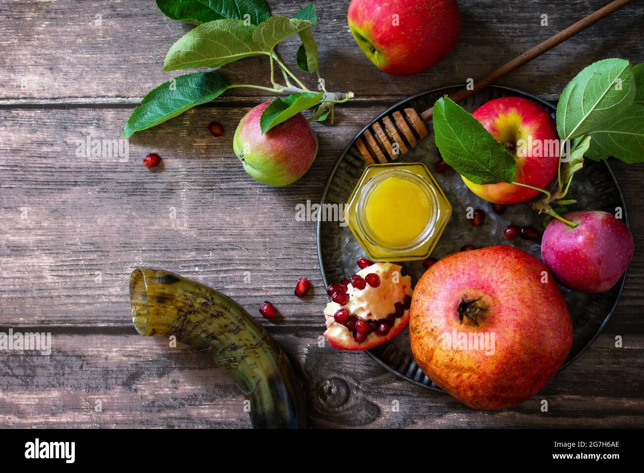 Immagine religiosa del concetto di Rosh hashanah (festa ebraica di Capodanno). Simboli tradizionali: Miele, mele e melograno su un tavolo rustico scuro. Vista dall'alto Foto Stock