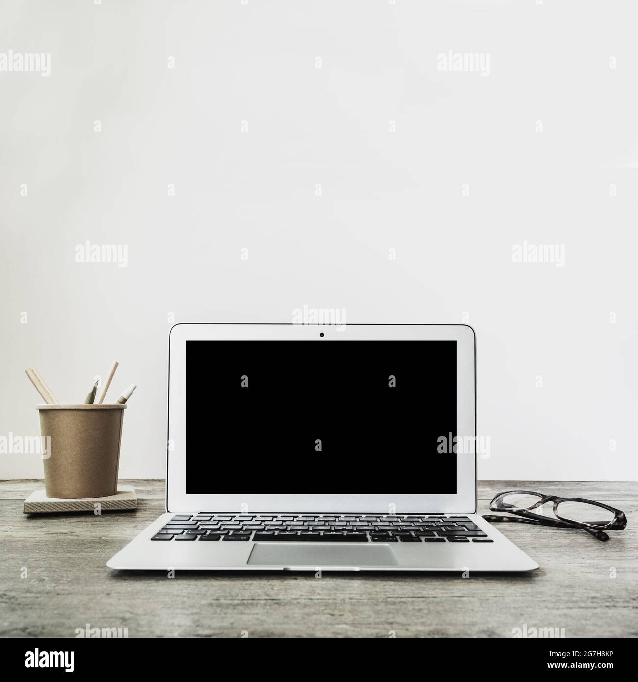 Computer portatile con schermo nero vuoto su scrivania in legno. Interni  domestici o sfondo ufficio. Spazio di copia Foto stock - Alamy