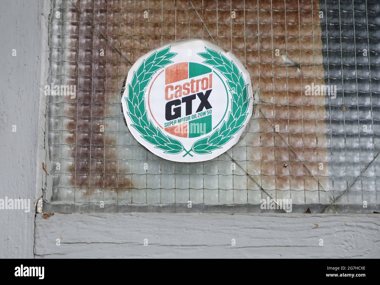 Adesivo Castrol presso un vecchio negozio di riparazione auto. Foto Stock