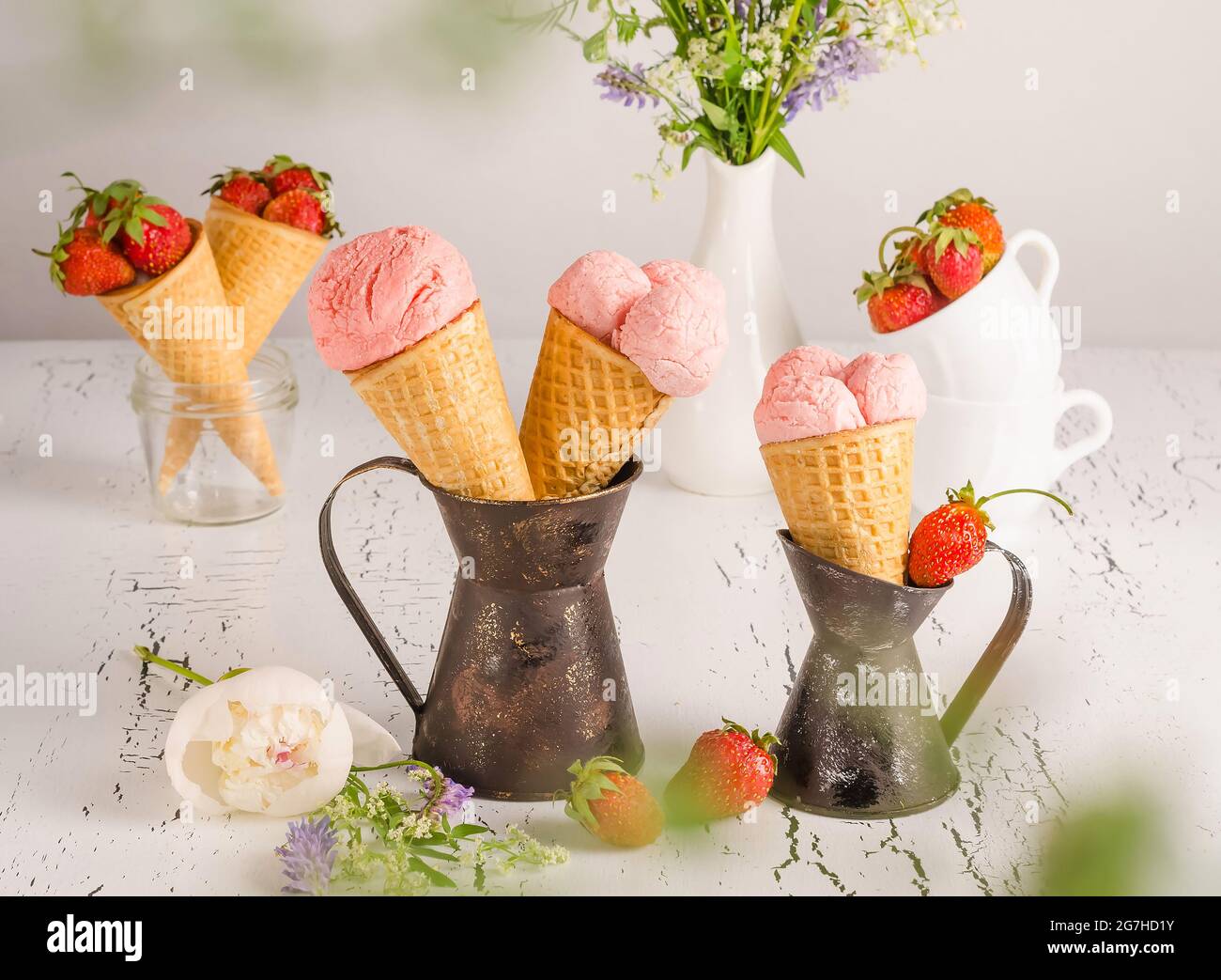 Gelato alla fragola con fragole fresche in cialde su sfondo bianco di legno Foto Stock