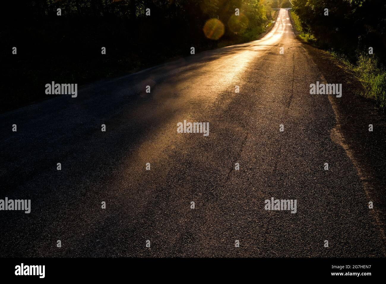 Tramontare il sole splende su una strada rurale vicino a Cooperstown, New York. Foto Stock