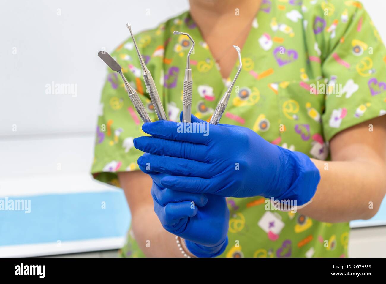 Medico dentista femminile che tiene gli attrezzi dell'apparecchiatura dentale Foto Stock