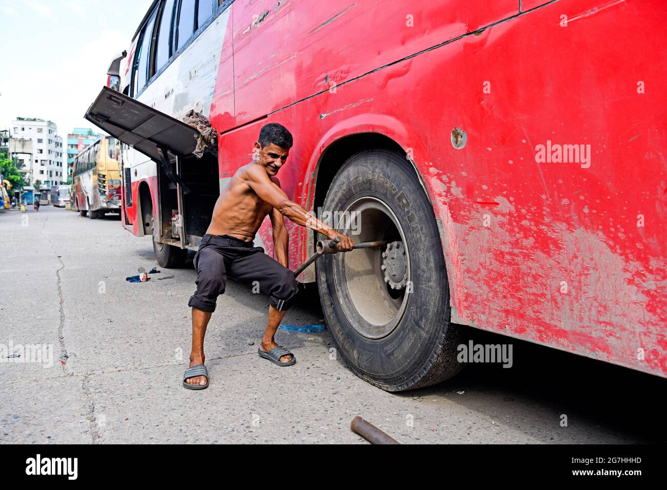 Dhaka, Bangladesh. 14 luglio 2021. Un operaio dei trasporti ha visto occupato riparare il pneumatico di un autobus al terminal degli autobus Mohakhali.il governo ha allentato il blocco per una settimana davanti a Eid. I trasporti pubblici partono da mezzanotte in tutto il paese. (Foto di Piyas Biswas/SOPA Images/Sipa USA) Credit: Sipa USA/Alamy Live News Foto Stock