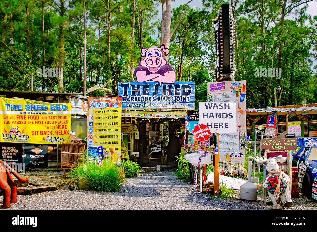 Una mascotte di maiale muscolata è presente su un cartello presso lo Shed Barbeque and Blues Joint, il 4 luglio 2021, a Ocean Springs, Mississippi. Foto Stock