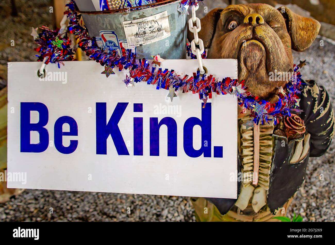 Una statua del maggiordomo dei bulldog contiene un secchio di ghiaccio e un cartello "Be Kind" al Shed Barbeque and Blues Joint, 4 luglio 2021, a Ocean Springs, Mississippi. Foto Stock