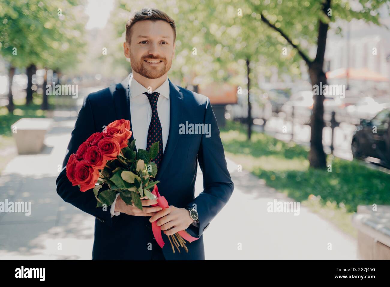 Sorridente gentiluomo elegante e capiente in smoking blu scuro con bouquet  grande Foto stock - Alamy