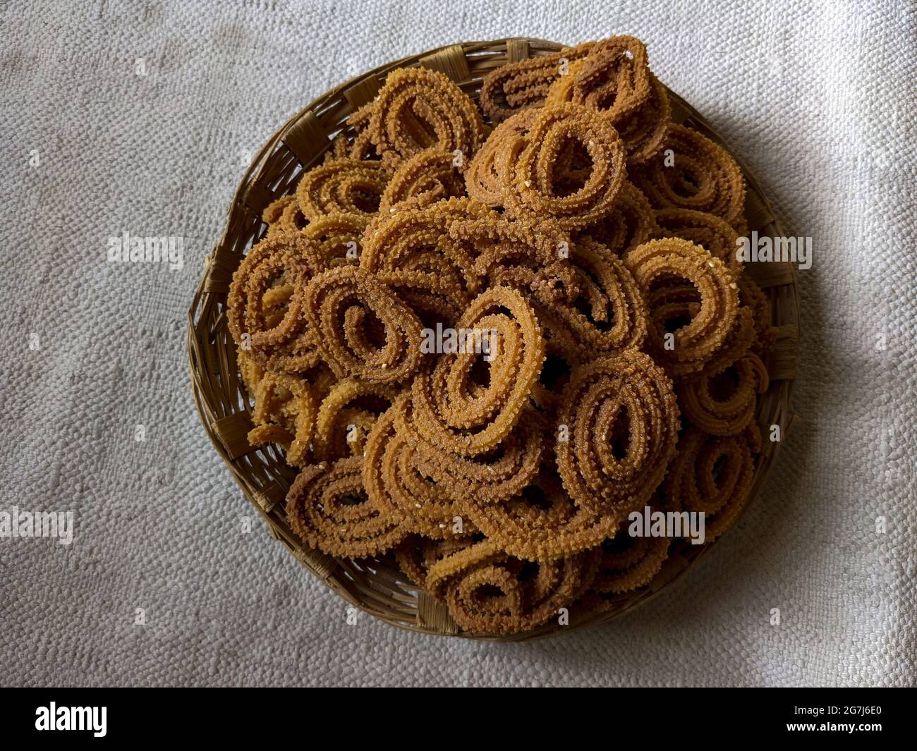 Vista dall'alto dello spuntino indiano "Murukku" in un bel cesto di vimini, su un tavolo Foto Stock