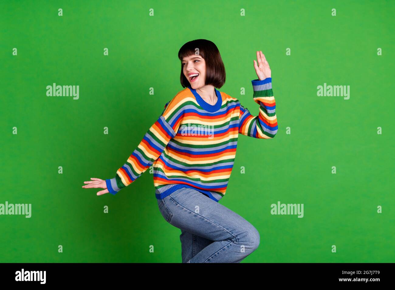 Foto di affascinante giovane donna felice look spazio vuoto danza funky moo isolato su sfondo di colore verde Foto Stock