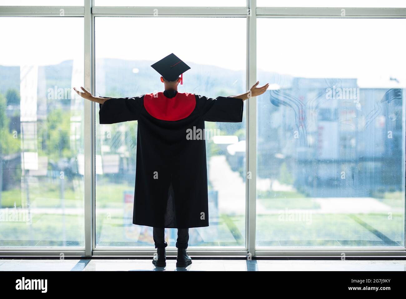 Uomo studente laureato indiano indossando cappello e abito di laurea Foto Stock