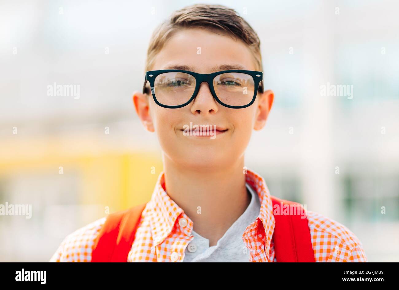 Ritratto di un ragazzo carino in occhiali che va a scuola con il suo zaino scuola, studente ragazzo sulla strada per la scuola, imparare per i bambini Foto Stock