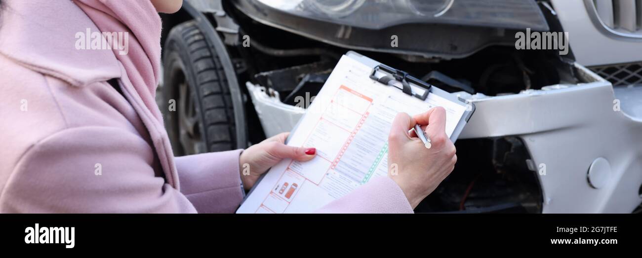 L'agente assicurativo femminile registra un caso assicurativo per incidente d'auto Foto Stock
