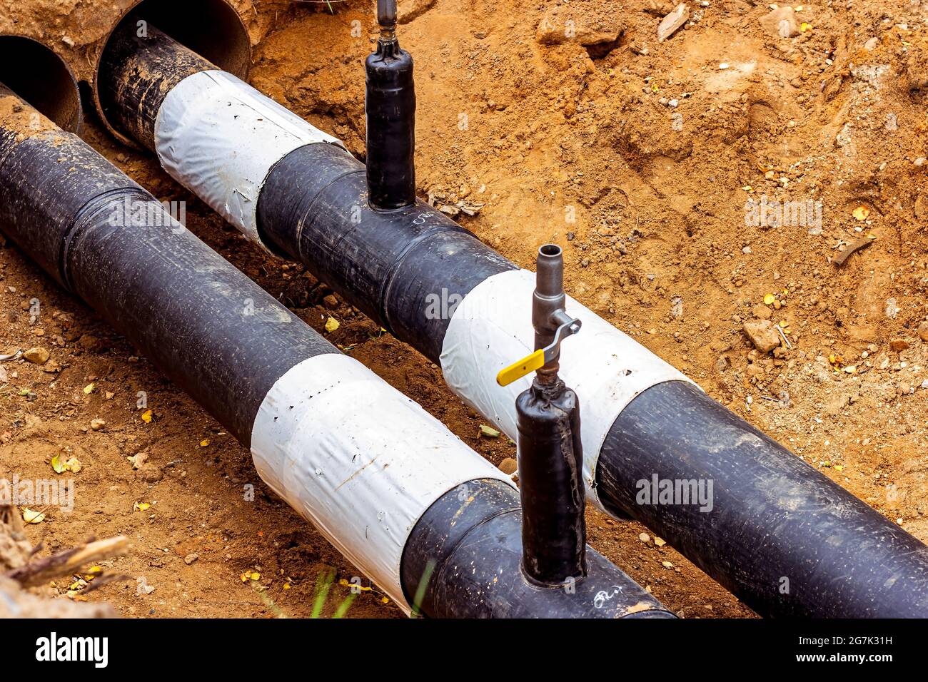 Installazione dell'unità di distribuzione della rete di riscaldamento e di alimentazione dell'acqua. Telaio per il collegamento di tubi nella trincea di terra. Foto Stock