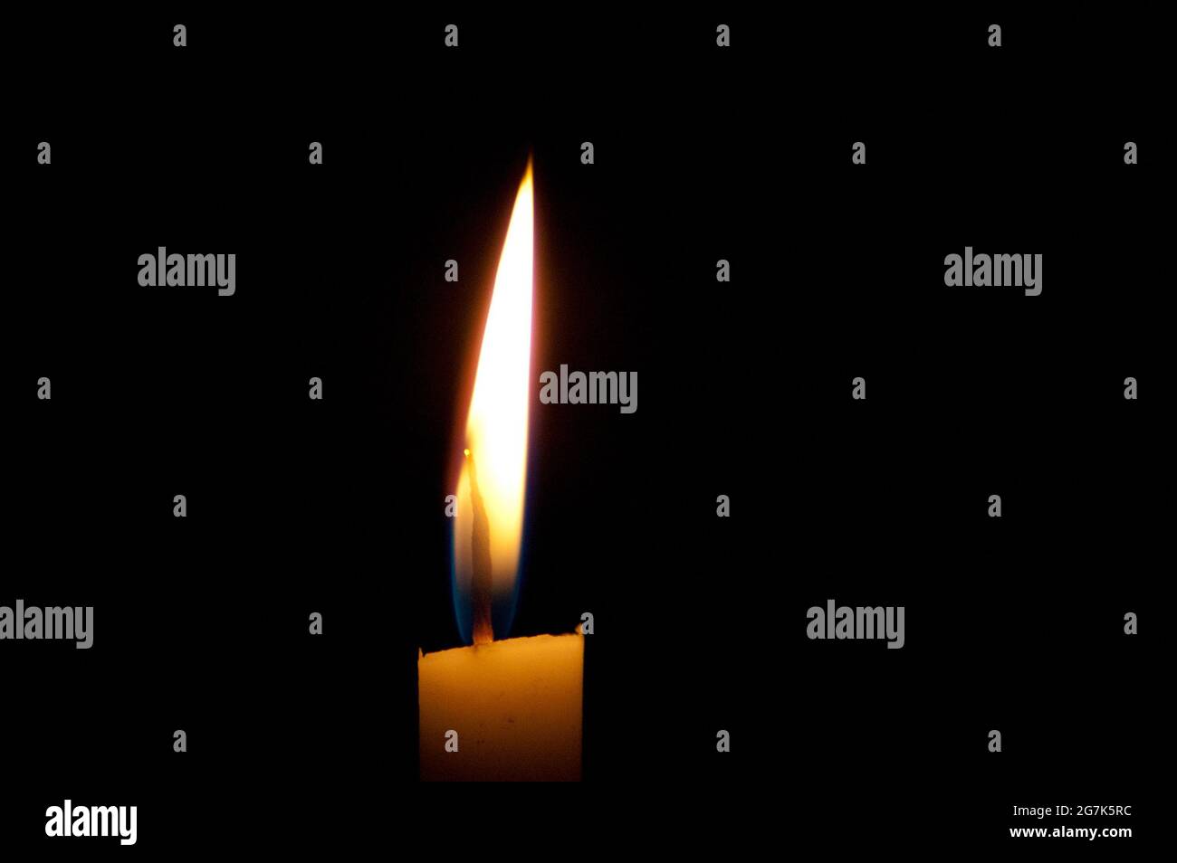 Primo piano di una candela calda e morbida che brucia al buio Foto Stock
