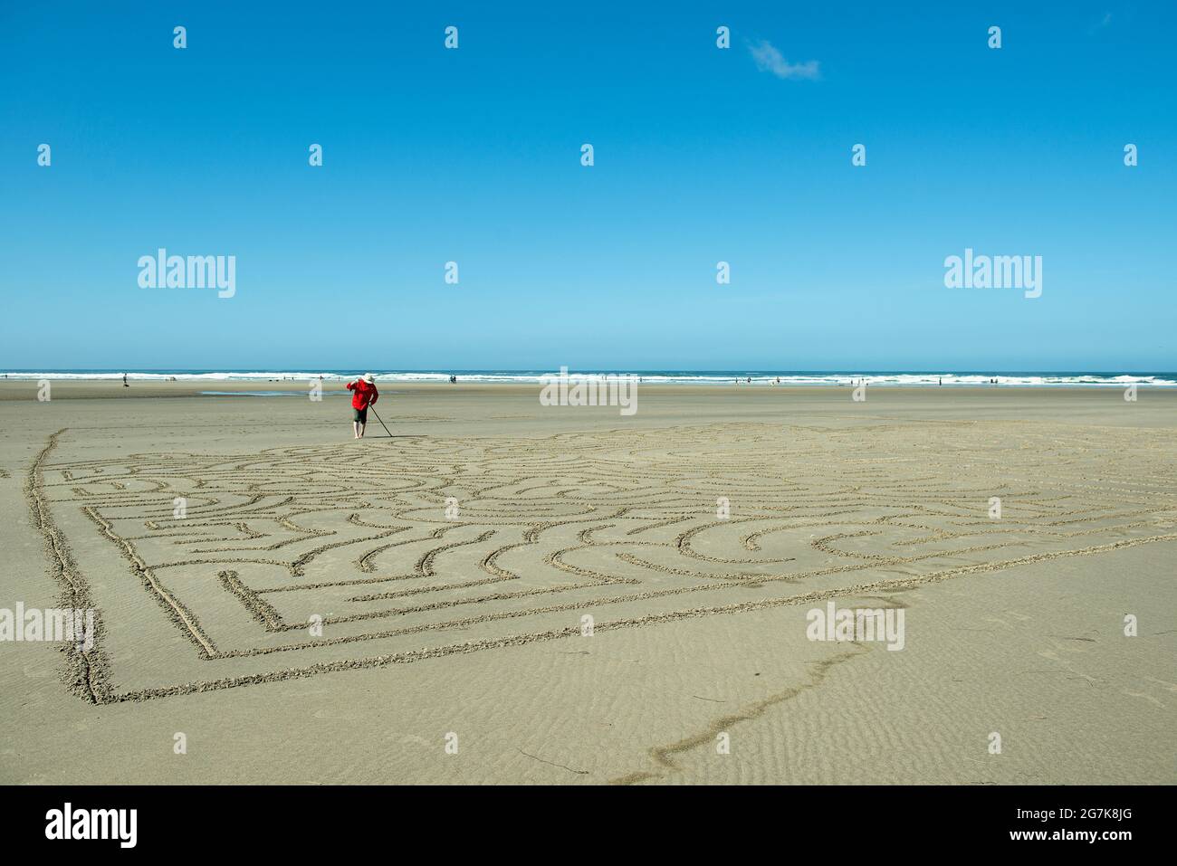 Uomo che fa un labirinto di spiaggia a Cannon Beach, Oregon Foto Stock