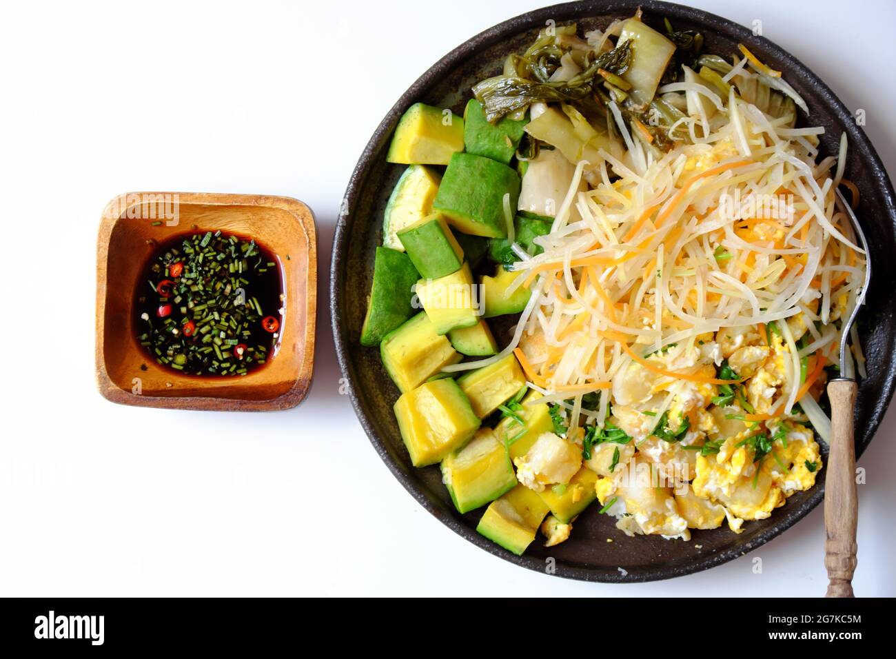 Vista dall'alto piatto di pasta fritta con uova, piatto semplice e delizioso per pasto vegano su sfondo bianco, mangiare con avocado Foto Stock