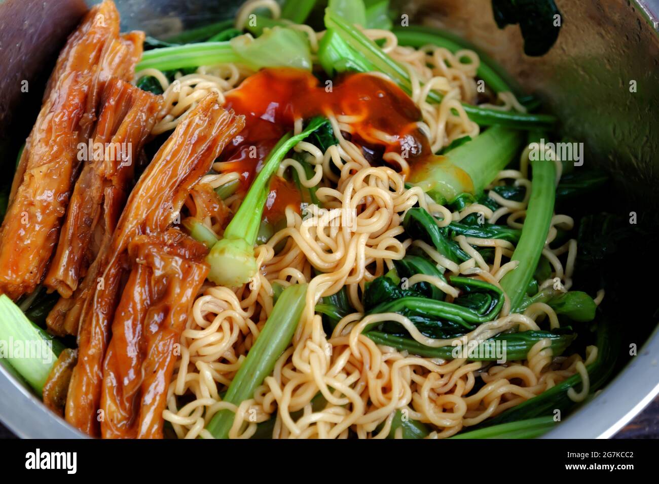 Cibo vegano veloce ed economico per colazione da noodle istantaneo, fritto con kale e salsa di pomodoro Foto Stock