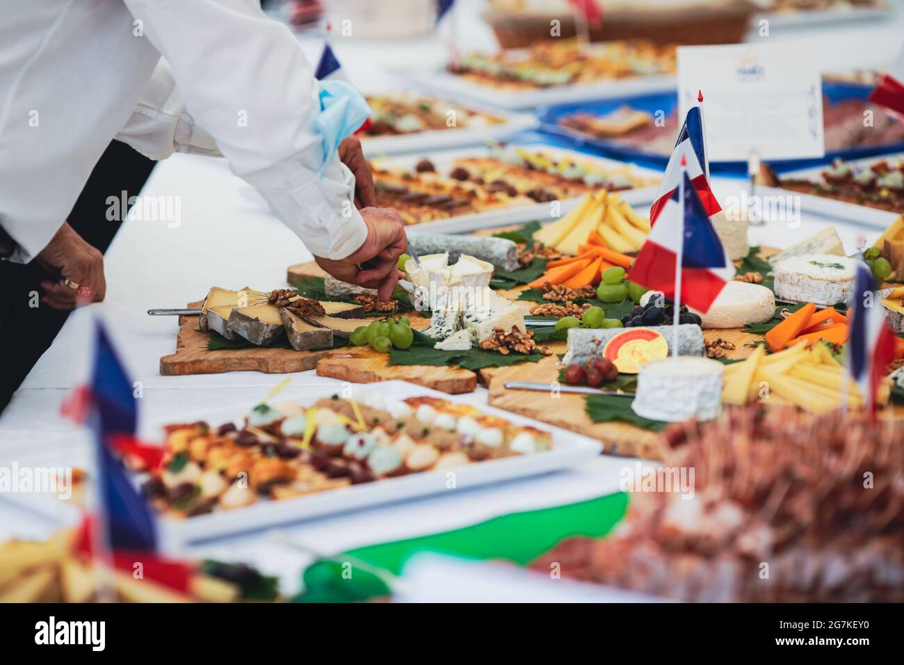 Immagine della profondità di campo poco profonda (fuoco selettivo) con persone che mangiano aperitivi di cucina francese da un tavolo. Foto Stock