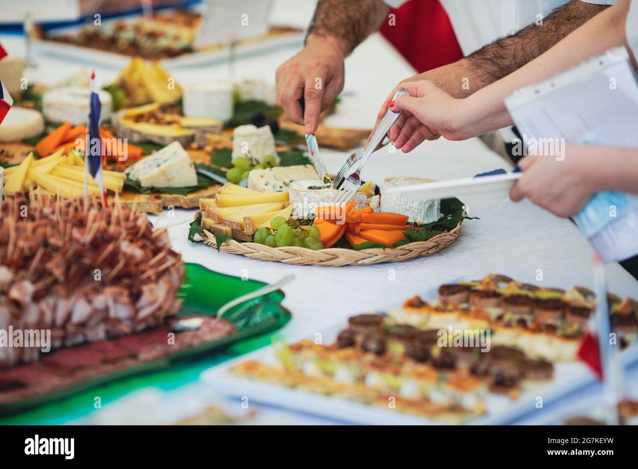Immagine della profondità di campo poco profonda (fuoco selettivo) con persone che mangiano aperitivi di cucina francese da un tavolo. Foto Stock