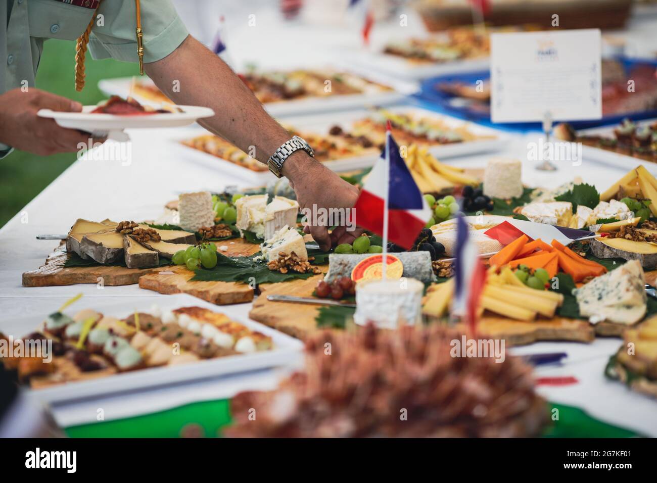 Immagine della profondità di campo poco profonda (fuoco selettivo) con persone che mangiano aperitivi di cucina francese da un tavolo. Foto Stock