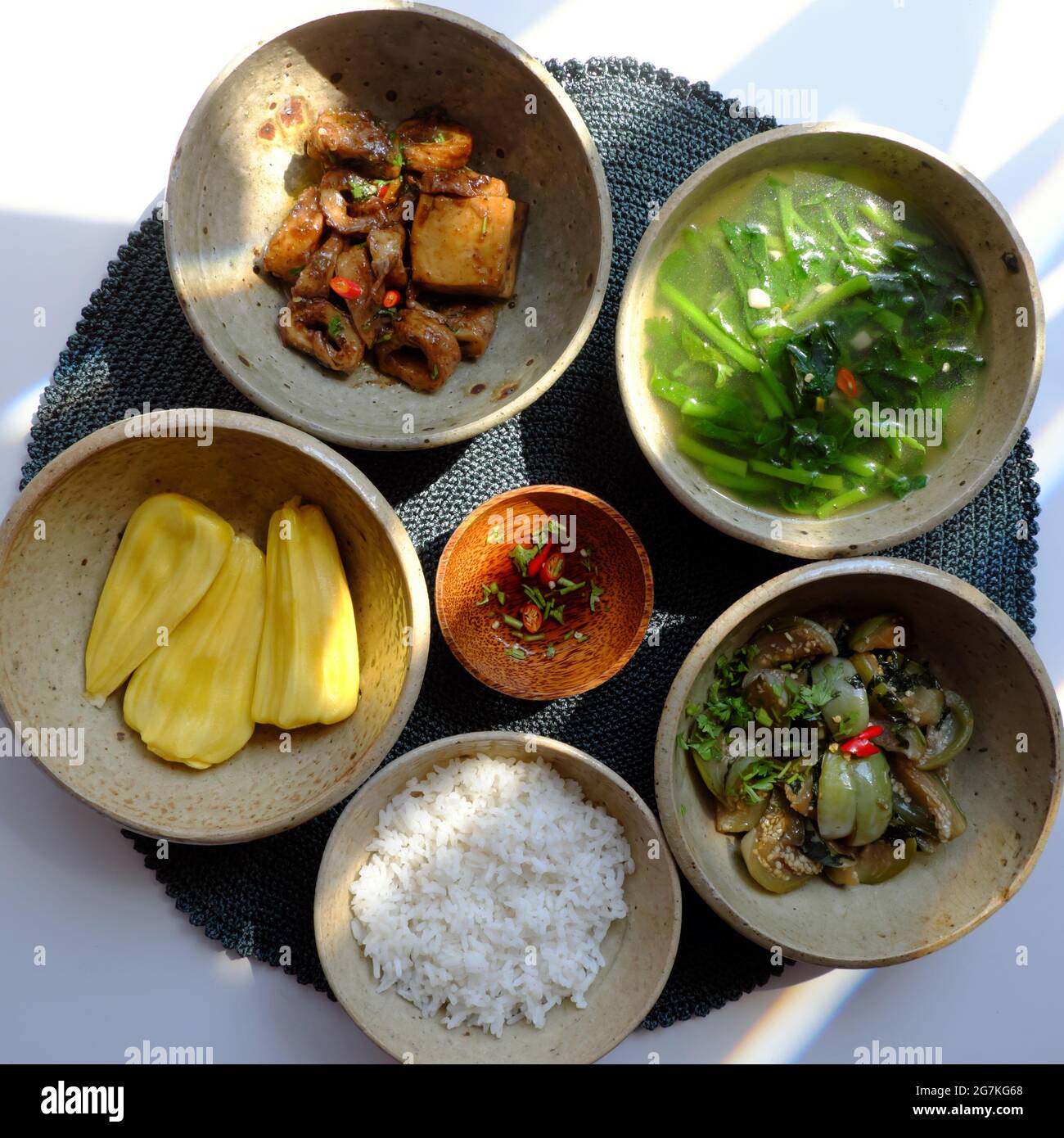 Vassoio vietnamita cibo vegano, ciotola di riso, melanzane fritte, cuoco di seitan con salsa, zuppa di spinaci, menu dieta non di carne per il pasto giornaliero di famiglia buono per heath Foto Stock