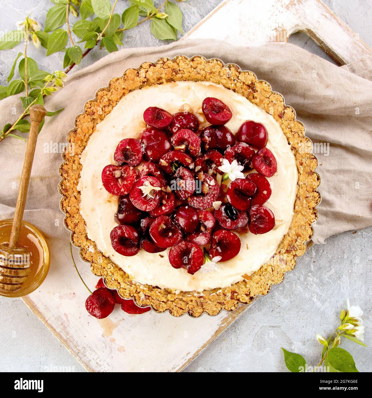 Crostata di vanila di ciliegia ricoperta di frutti di bosco su sfondo grigio chiaro. Vista dall'alto, disposizione piatta Foto Stock