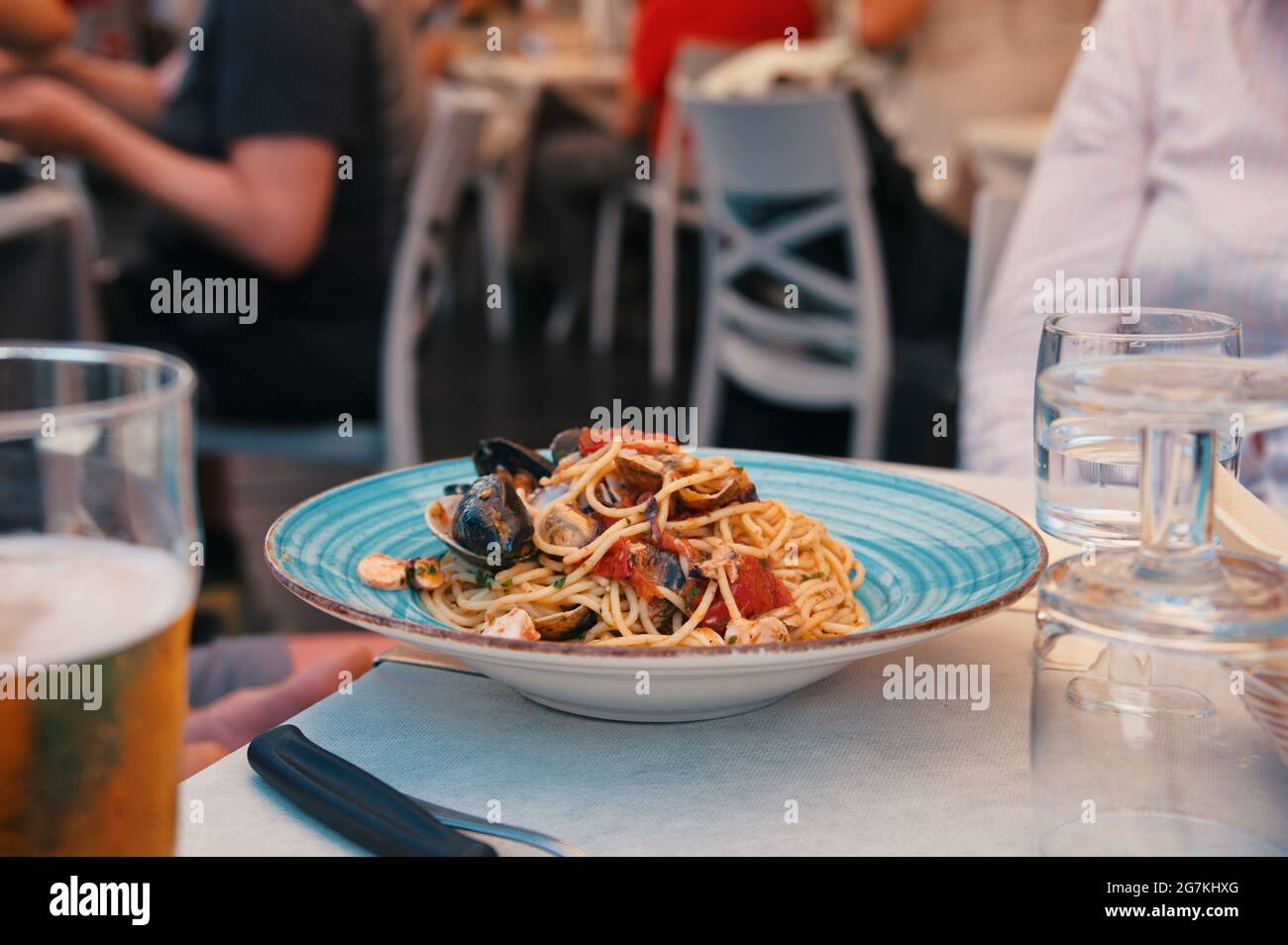 Pesce con pasta al tavolo nel ristorante Foto Stock