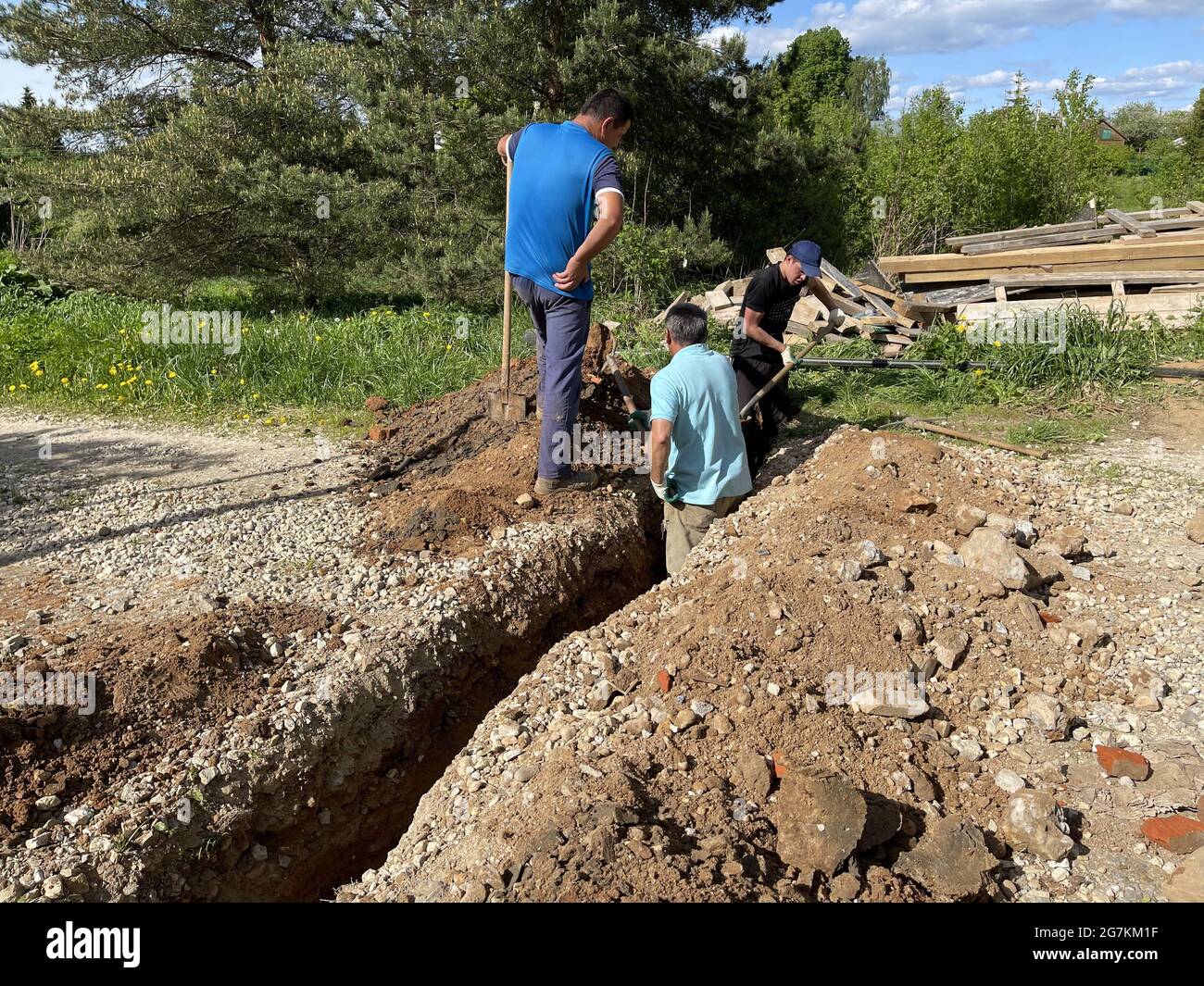 Руза, RUSSIA - 25 maggio 2021: Un team di digger conduce un tubo per il gas naturale al confine della casa di terra. Posa del gasdotto. Foto Stock