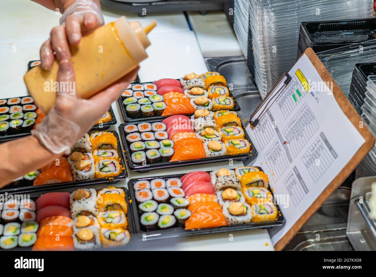 Preparazione di sushi giapponesi. Panini Maki con tonno, salmone, gamberi, granchio e avocado, sushi assortiti al mercato di Tarragona Foto Stock