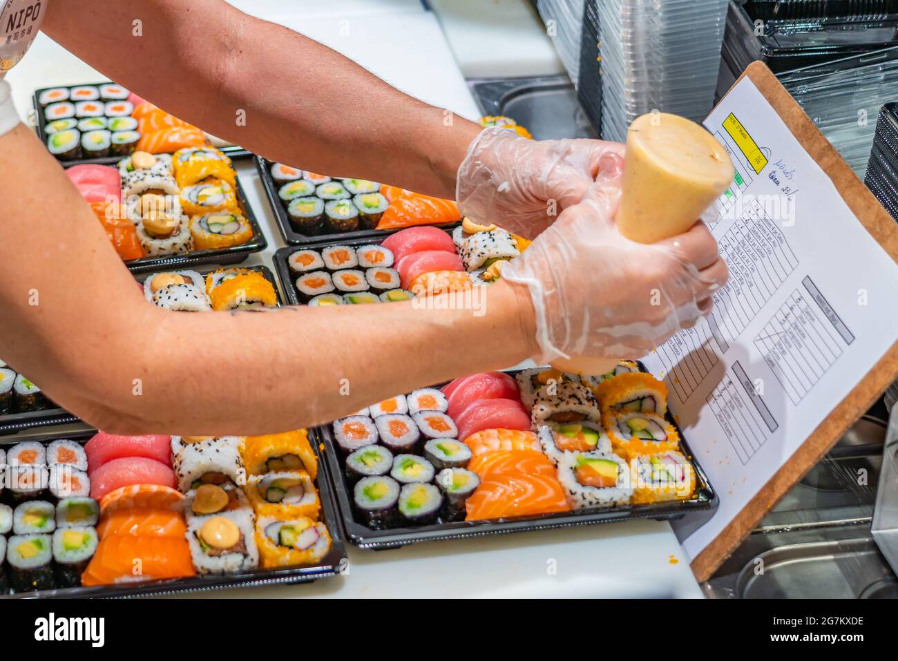 Preparazione di sushi giapponesi. Panini Maki con tonno, salmone, gamberi, granchio e avocado, sushi assortiti al mercato di Tarragona Foto Stock