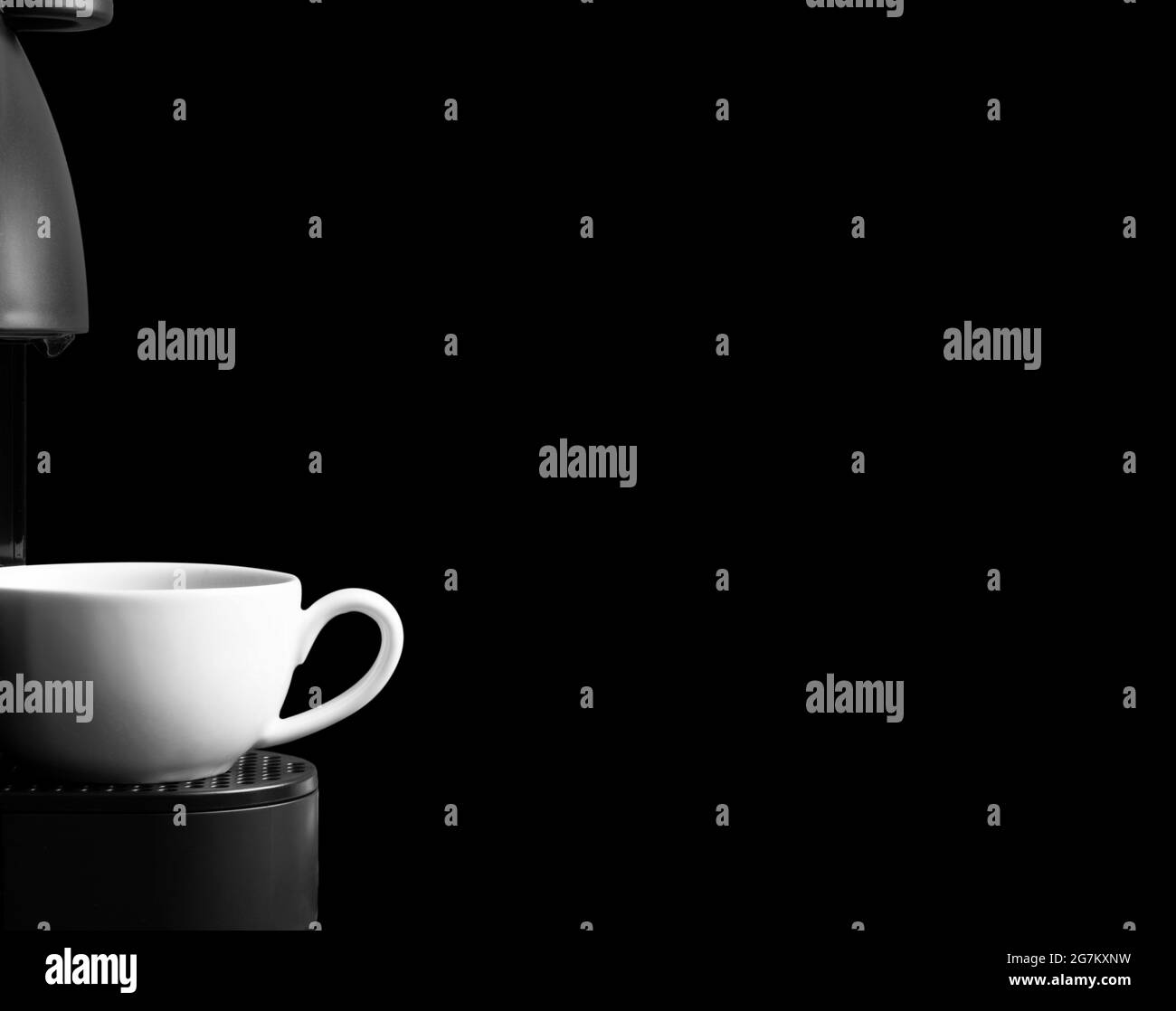 Macchina da caffè automatica con capsule di caffè o cialde che versano una bevanda espresso. Preparazione del caffè in una macchina da caffè. Preparazione di un caffè. Bianco e nero. Foto Stock