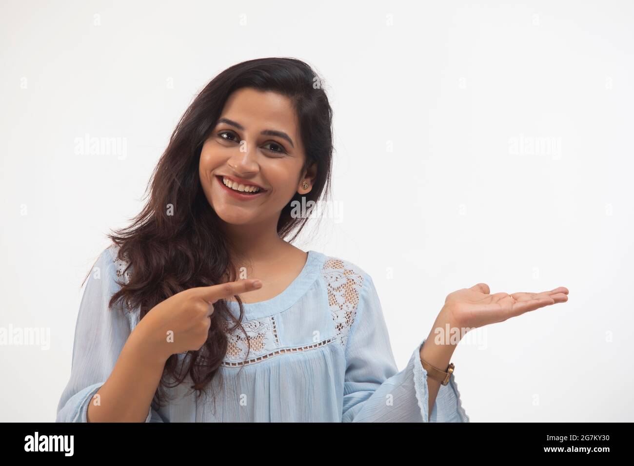 UNA GIOVANE DONNA CHE PUNTA IL DITO VERSO L'ALTRA MANO Foto Stock