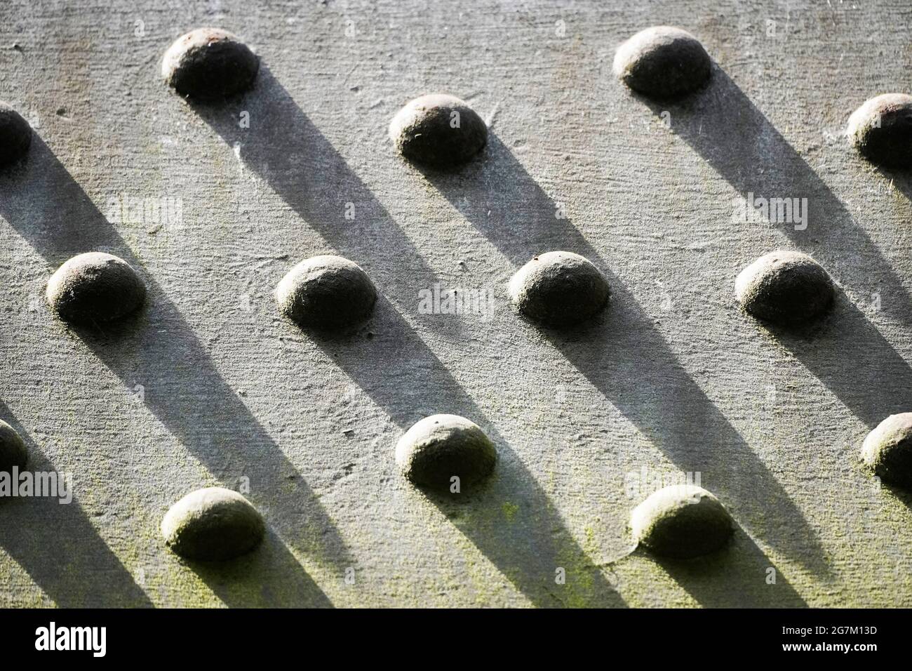 Primo piano astratto di rivetti metallici su una struttura in acciaio. Contesto industriale. Foto Stock