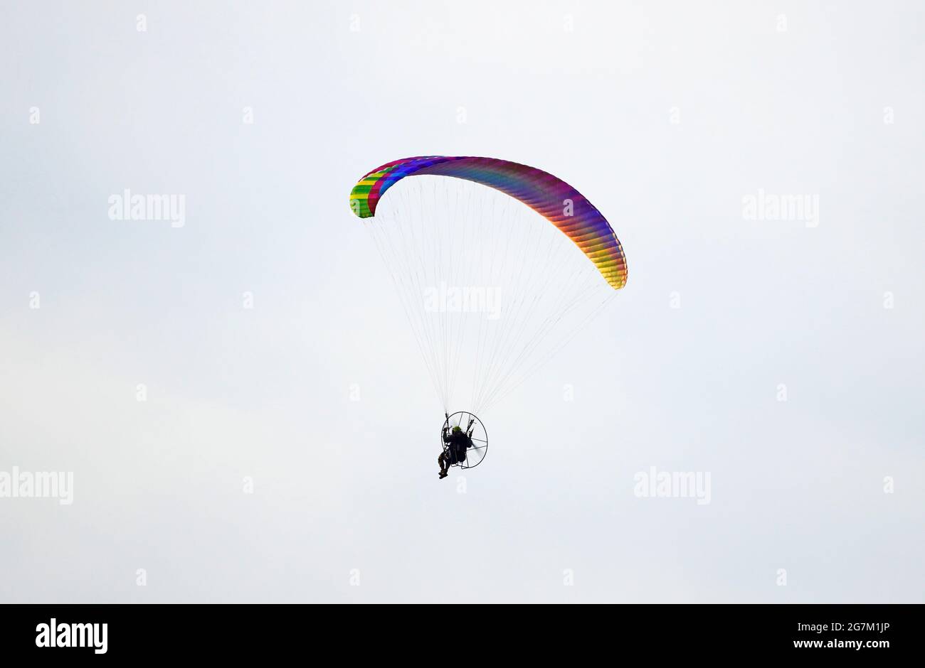 Parapendio con parapendio motorizzato. Parapendio colorato in volo. Foto Stock