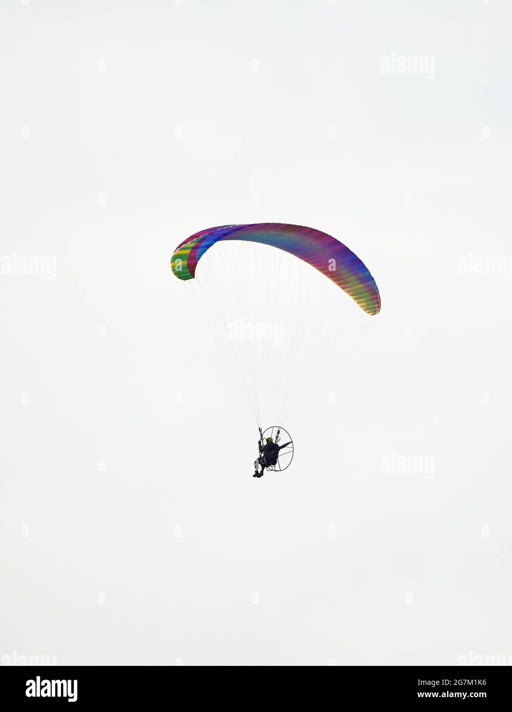 Parapendio con parapendio motorizzato. Parapendio colorato in volo. Foto Stock