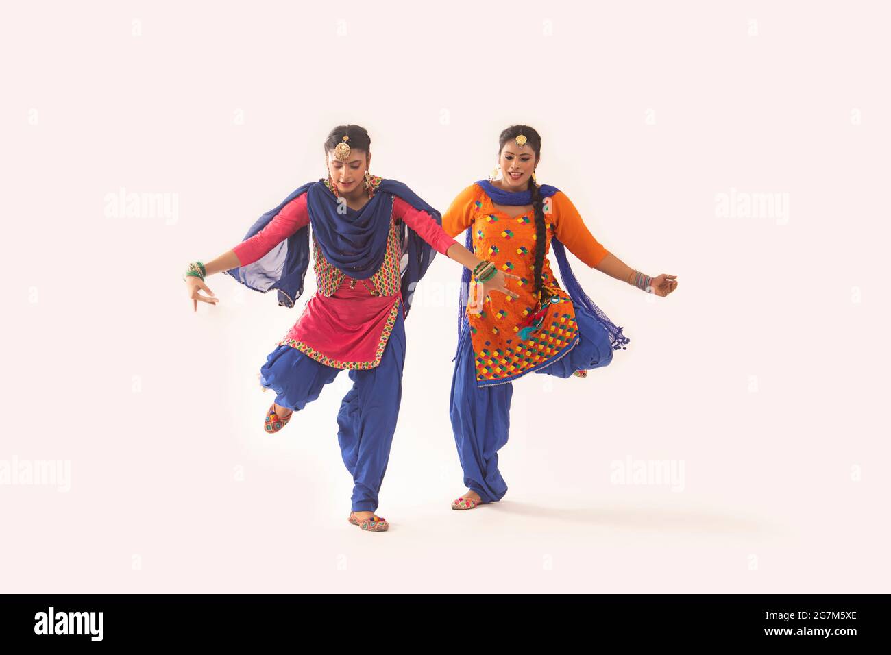 Due ballerini Giddha che eseguono un passo di danza con le mani allungate e una gamba sollevata. Foto Stock