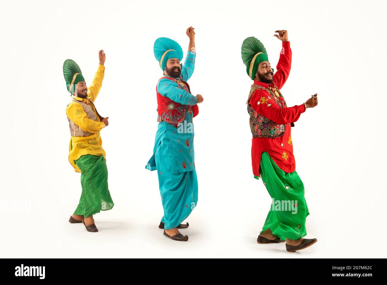 Tre ballerini Bhangra che eseguono un passo di danza con gesti a mano. Foto Stock