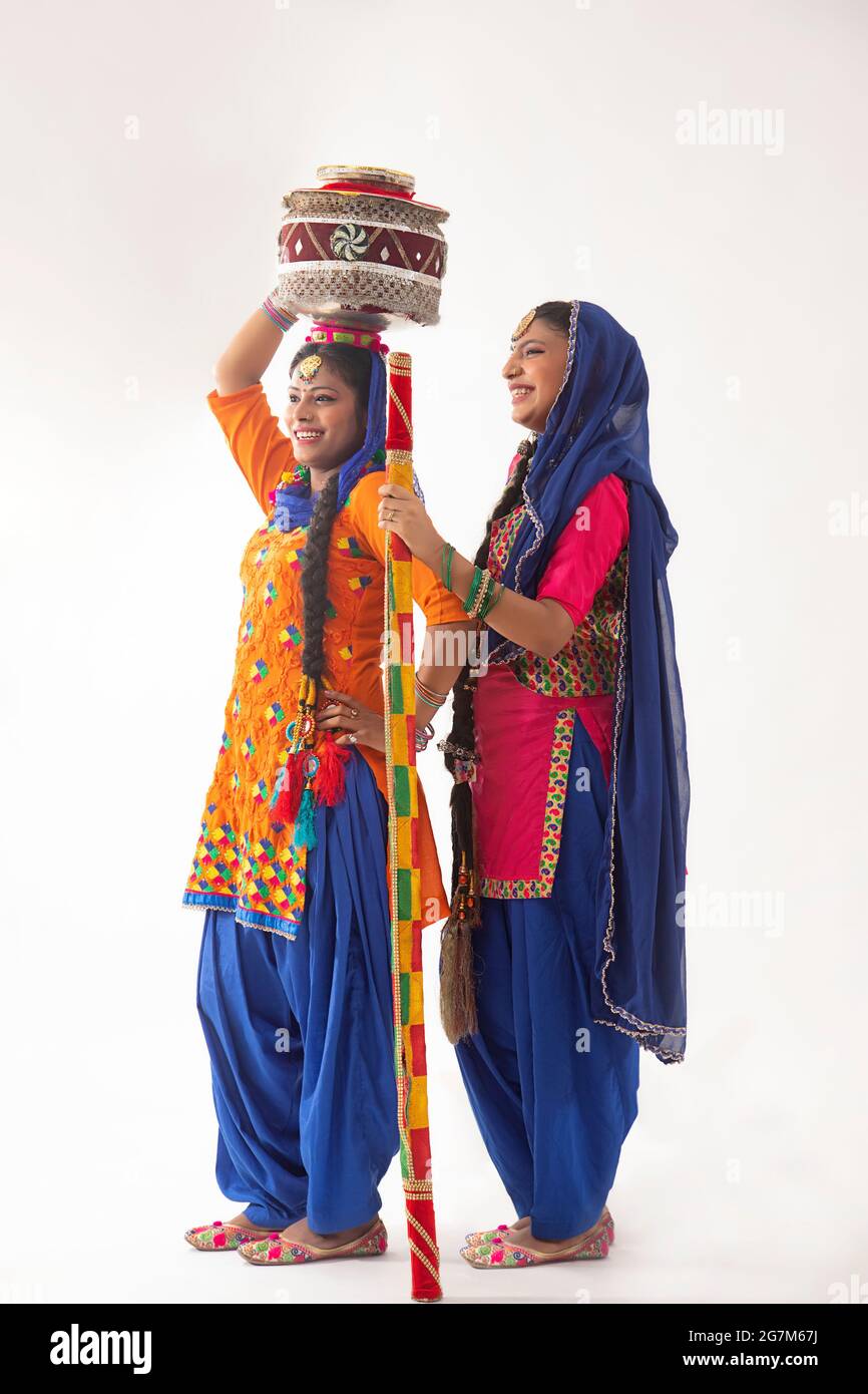 Due ballerini Giddha in piedi insieme con matki e bastone decorati. Foto Stock